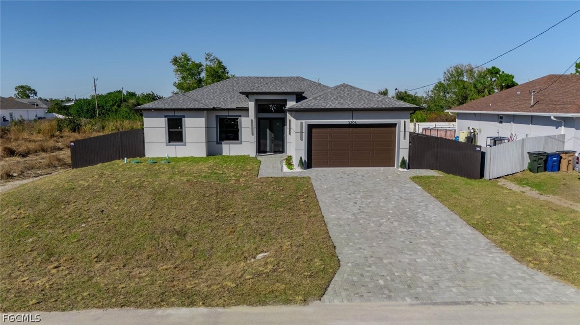 3206 14th Street Southwest Lehigh Acres, FL 33976 - Photo 33 of 38 a front view of a house with a garden and yard