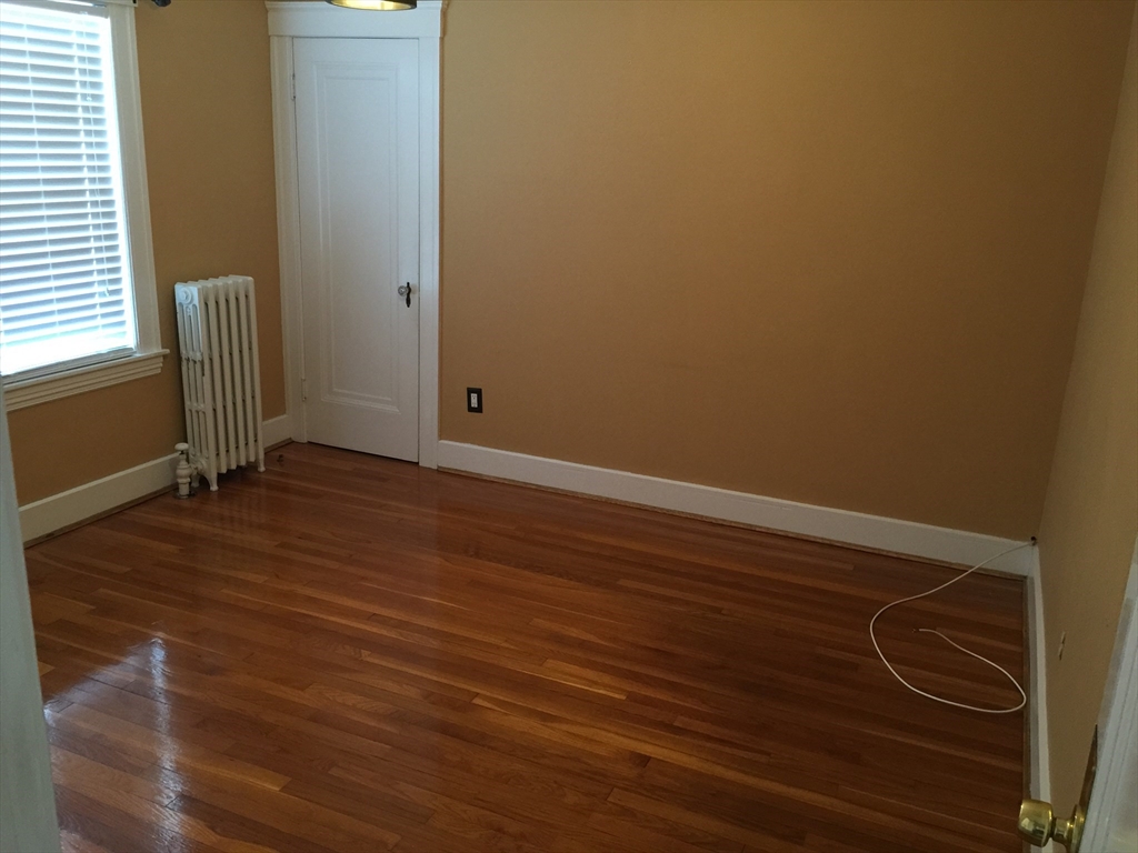 128 Institute Road, Unit 2 Worcester, MA 01602 - Photo 4 of 9 a view of an empty room with wooden floor and a window