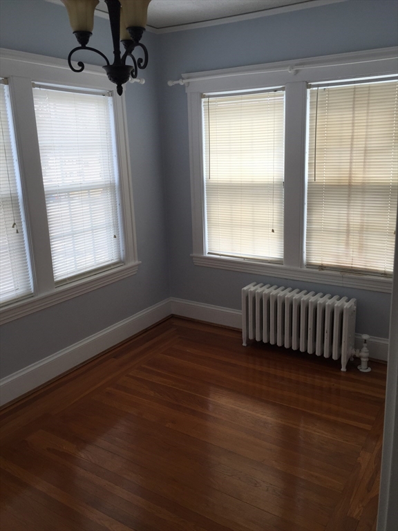 128 Institute Road, Unit 2 Worcester, MA 01602 - Photo 6 of 9 a view of an empty room with wooden floor and a window