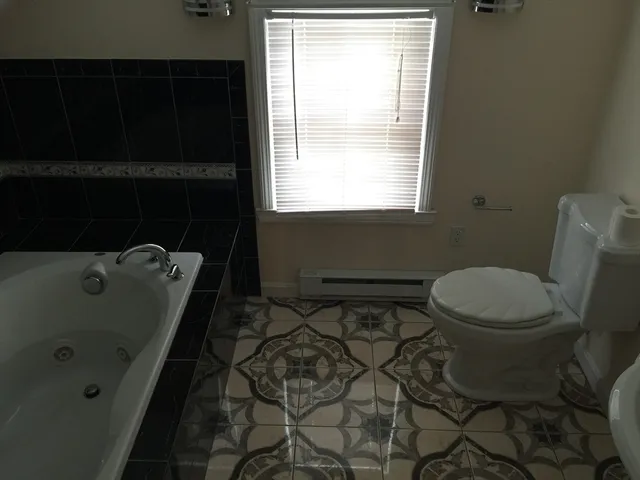 a bathroom with a sink toilet and window