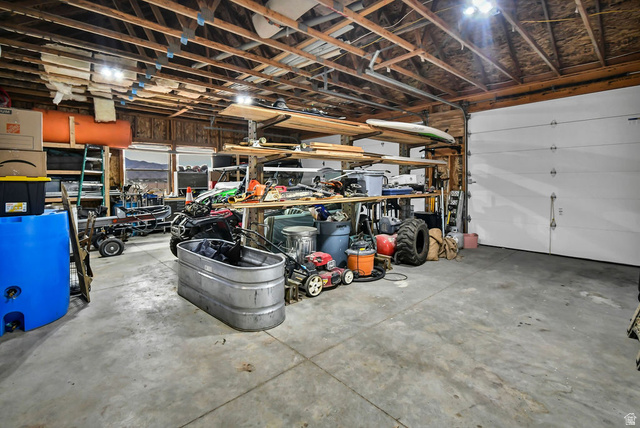 544 East 600 North, Unit 1 Joseph, UT 84739 - Photo 50 of 65 Spacious garage featuring a concrete floor, exposed wood beam ceiling, large roll-up door, and multiple windows