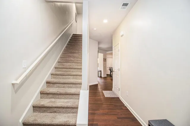 a view of a hallway with wooden floor and entryway