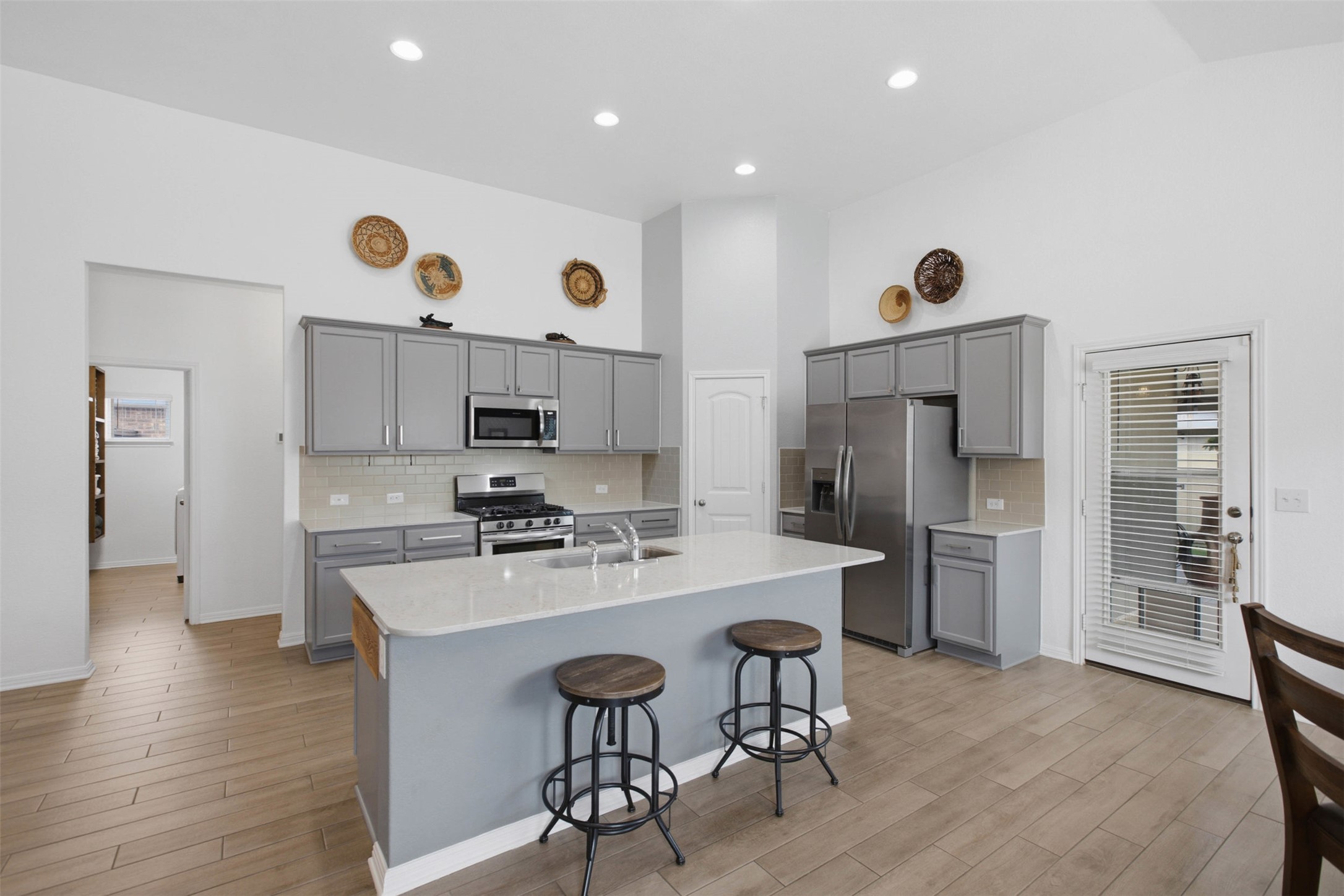 2413 Bridges Ranch Road Georgetown, TX 78628 - Photo 9 of 31 Culinary delights await in this bright kitchen, showcasing an island with seating and stainless steel appliances.