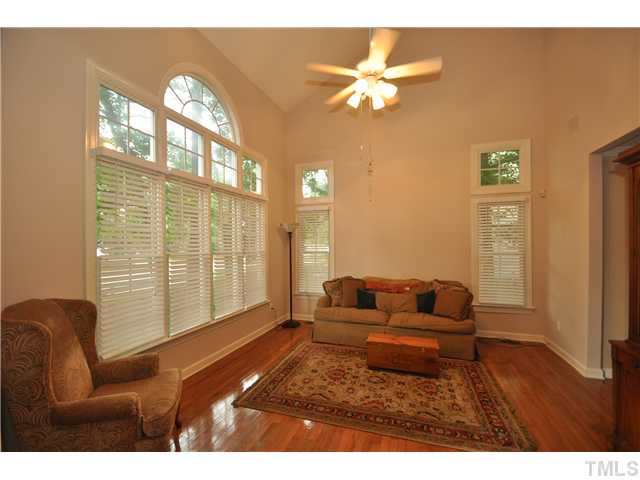 9008 Breeland Way Raleigh, NC 27613 - Photo 2 of 18 Formal living room with 2 story vaulted ceiling, gleaming hardwood floors, and wall of windows