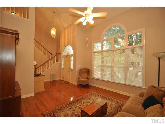 9008 Breeland Way Raleigh, NC 27613 - Photo 3 of 18 Formal living room with 2 story vaulted ceiling, gleaming hardwood floors, and wall of windows