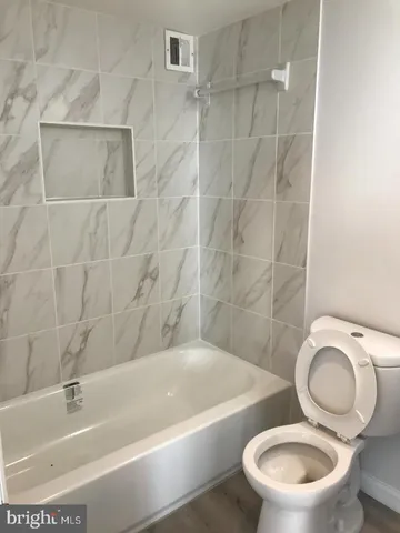 a white toilet sitting next to a bathtub