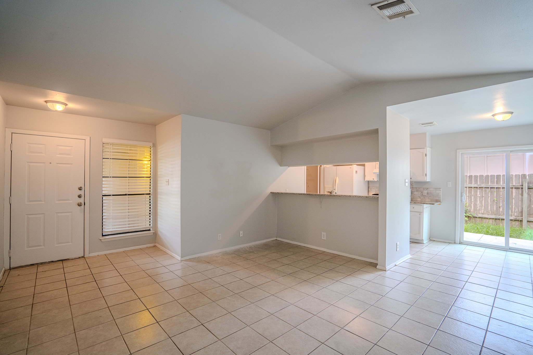 12403 Tree Line Drive, Unit B Austin, TX 78729 - Photo 3 of 16 an empty room with windows and refrigerator