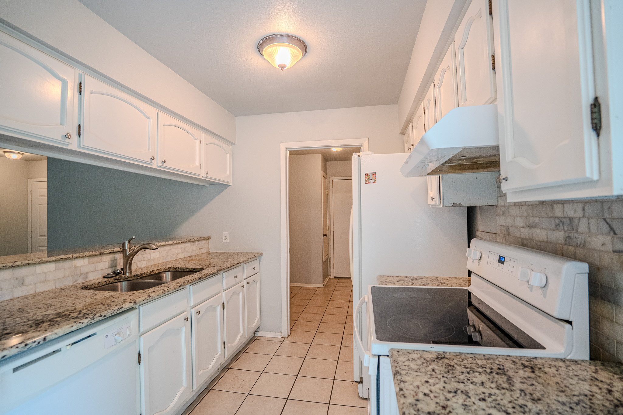 12403 Tree Line Drive, Unit B Austin, TX 78729 - Photo 7 of 16 a kitchen with granite countertop a sink and a stove