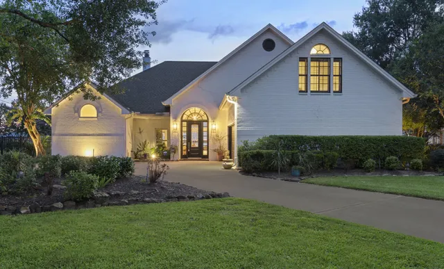 a view of a house with brick walls and a yard with plants