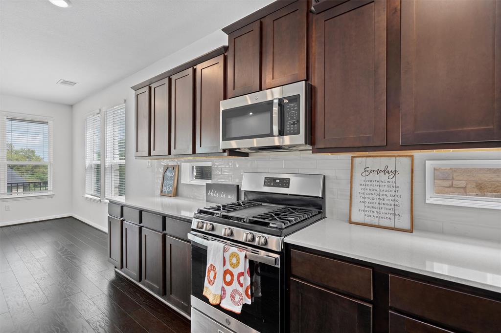 236 Prato Place Georgetown, TX 78628 - Photo 15 of 40 A contemporary kitchen showcasing rich cabinetry, sleek countertops, and modern stainless steel appliances.