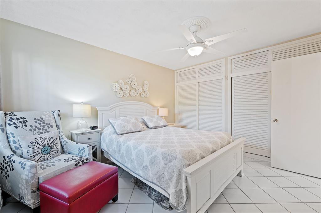 701 South Riverside Drive, Unit 107 Pompano Beach, FL 33062 - Photo 19 of 27 a spacious bedroom with two bed and a chandelier