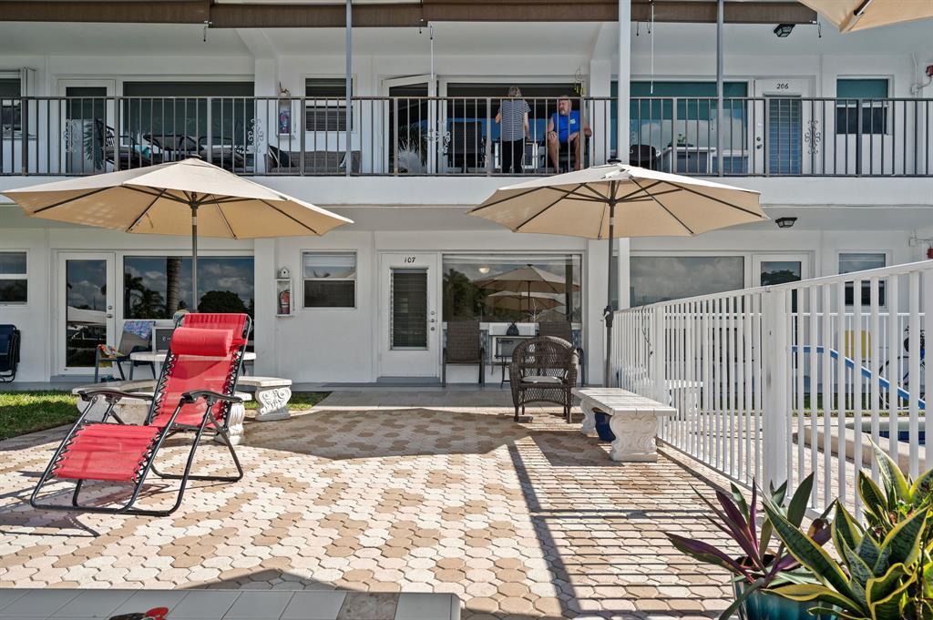 701 South Riverside Drive, Unit 107 Pompano Beach, FL 33062 - Photo 25 of 27 a view of a patio with a table and chairs under an umbrella