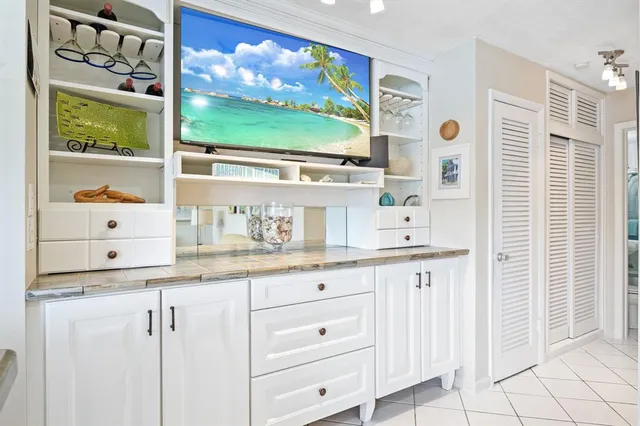 a kitchen with white cabinets a sink and a window