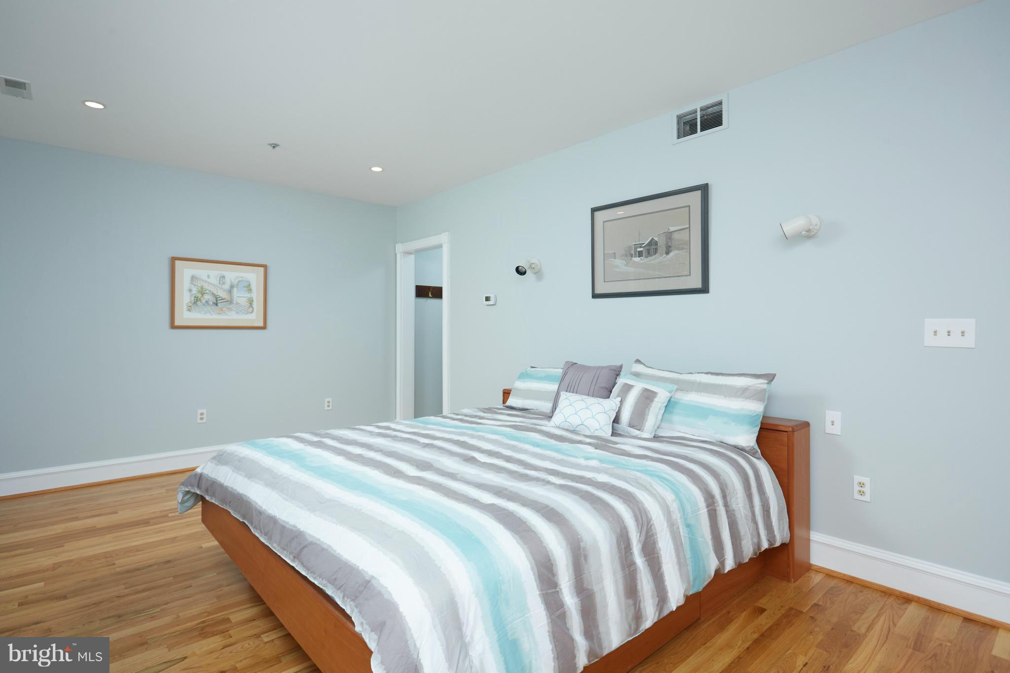 7447 Arlington Road Bethesda, MD 20814 - Photo 13 of 20 a bedroom with a bed and wooden floor
