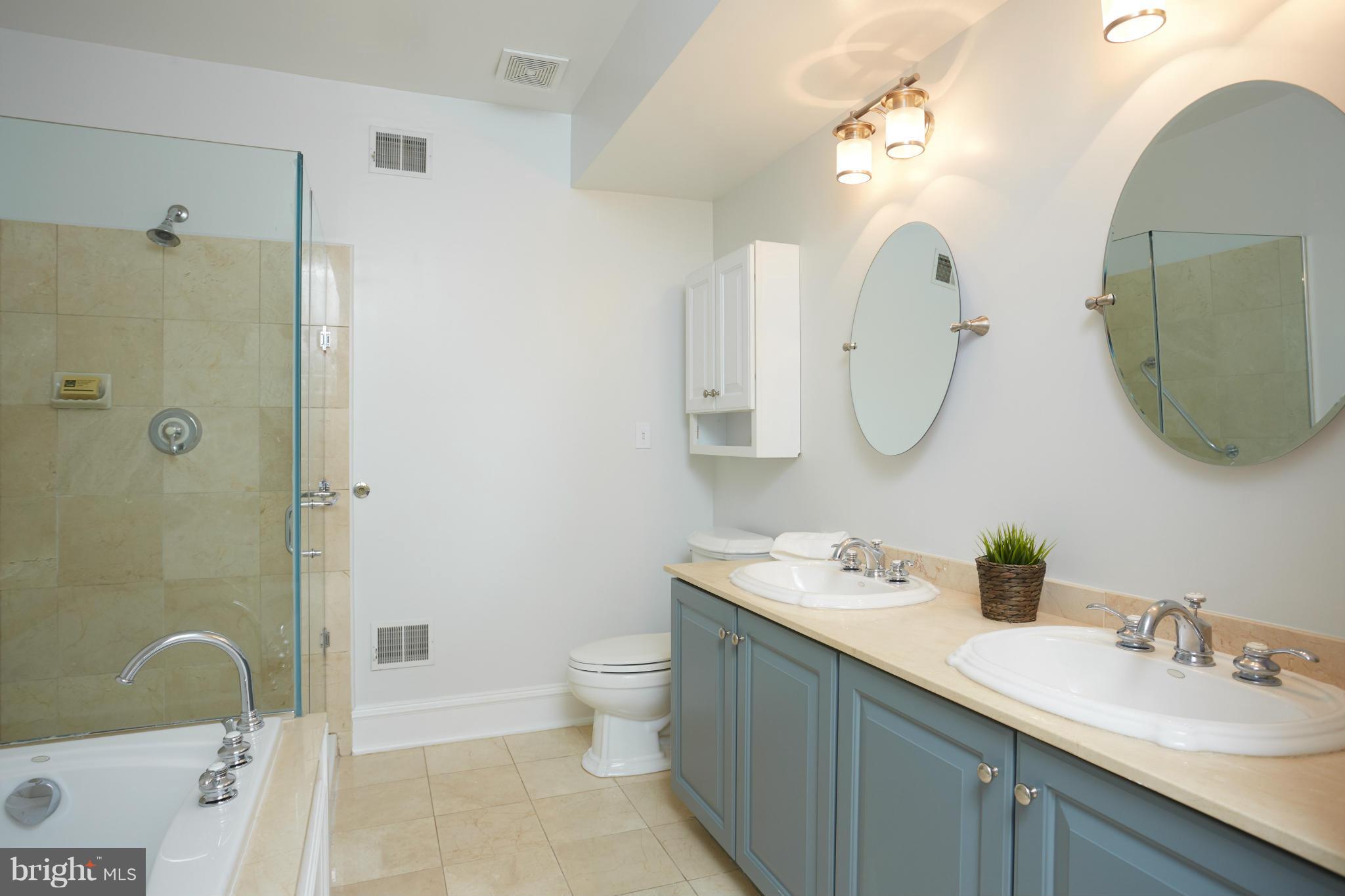 7447 Arlington Road Bethesda, MD 20814 - Photo 14 of 20 a bathroom with a double vanity sink mirror and toilet