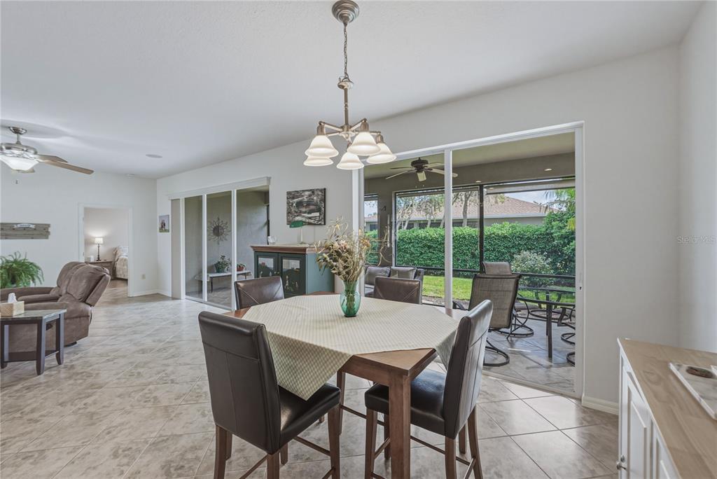 4489 Strathmore Drive Lake Wales, FL 33859 - Photo 15 of 89 a dining room with furniture a chandelier and a rug