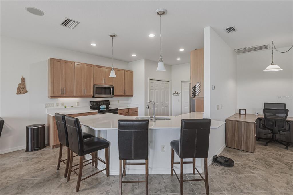 4489 Strathmore Drive Lake Wales, FL 33859 - Photo 18 of 89 a kitchen with kitchen island granite countertop wooden cabinets and refrigerator