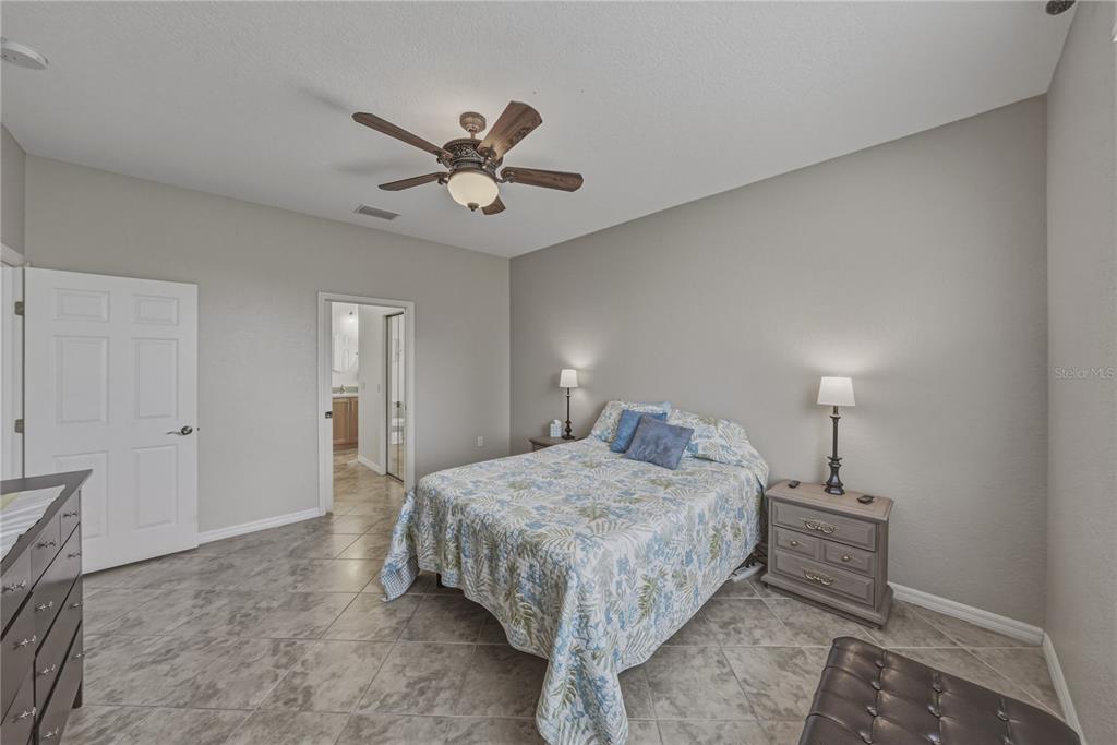 4489 Strathmore Drive Lake Wales, FL 33859 - Photo 28 of 89 a bedroom with a bed and a chandelier