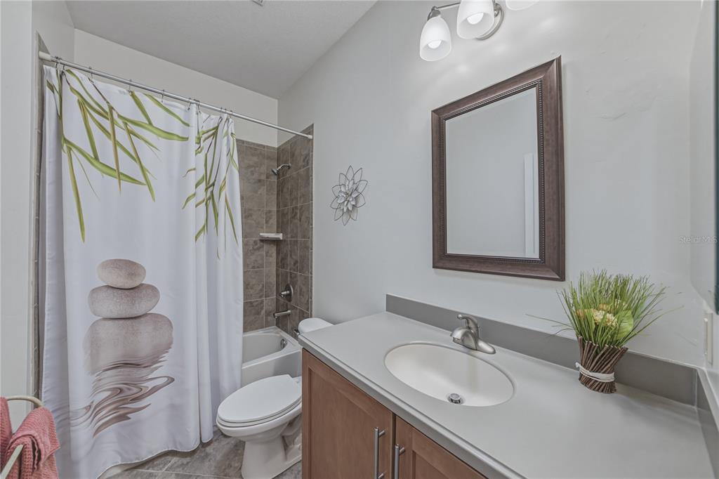 4489 Strathmore Drive Lake Wales, FL 33859 - Photo 40 of 89 a bathroom with a granite countertop sink toilet a large mirror and shower