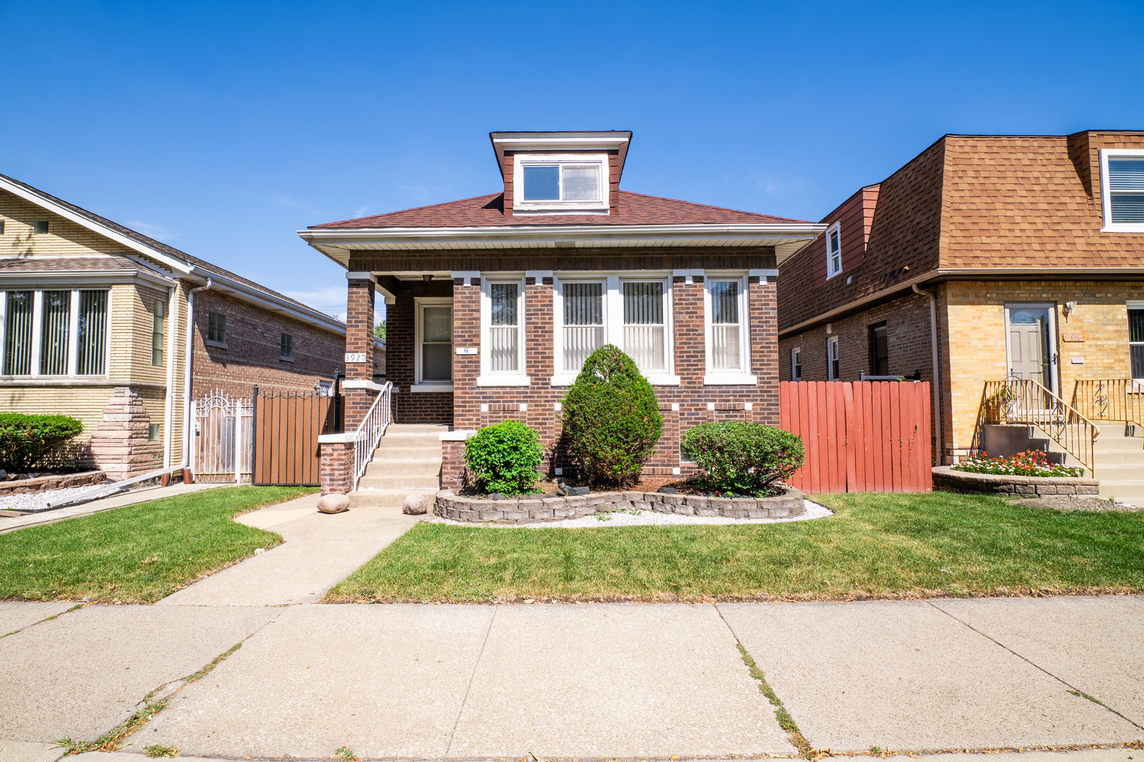 a front view of a house with a yard and potted plants