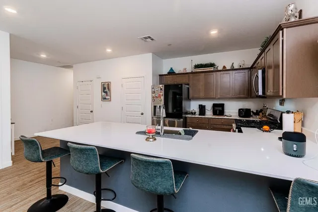 a kitchen with kitchen island a wooden floor and refrigerator