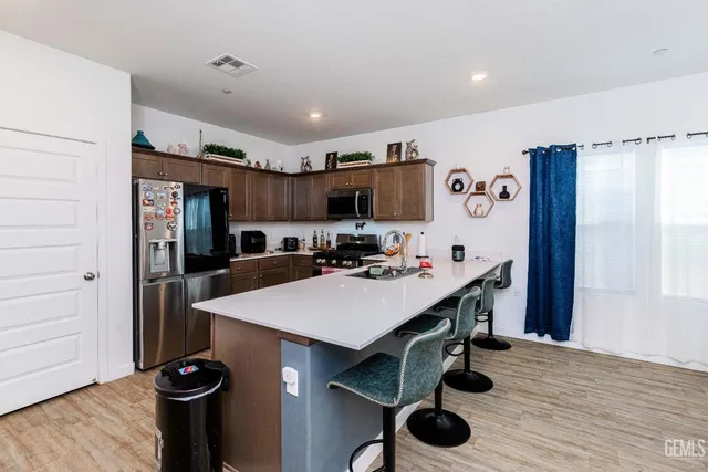 a large kitchen with lots of counter space a sink appliances and cabinets