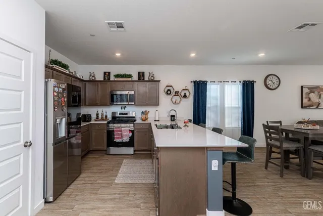 a kitchen with stainless steel appliances granite countertop a refrigerator sink and stove
