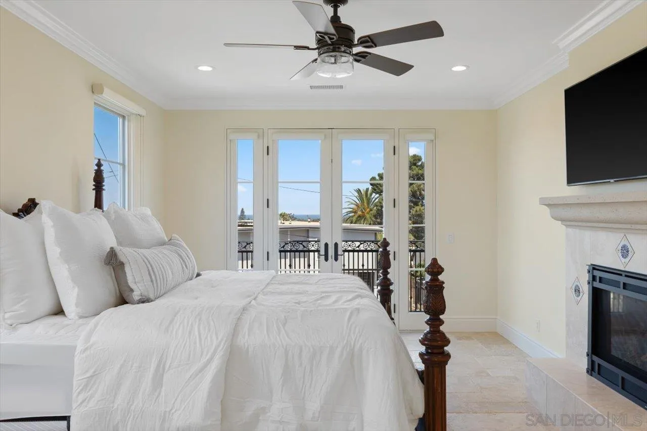 1015 Gardena Road Encinitas, CA 92024 - Photo 27 of 45 a bedroom with furniture a flat screen tv and a fireplace