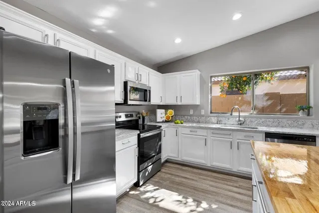 a kitchen with stainless steel appliances granite countertop a sink stove and refrigerator