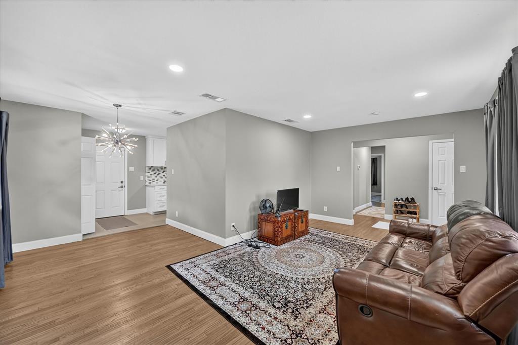 5906 Rocky Ridge Road Dallas, TX 75241 - Photo 8 of 35 Spacious living area featuring wood-finish flooring, recessed lighting, and a modern chandelier