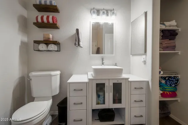 a bathroom with a sink a toilet and a mirror