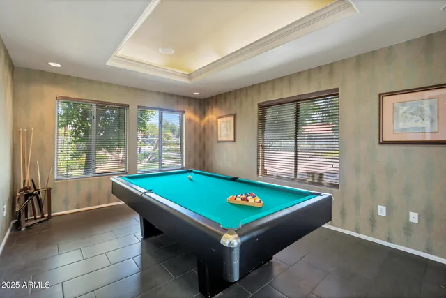 a room with pool table and windows