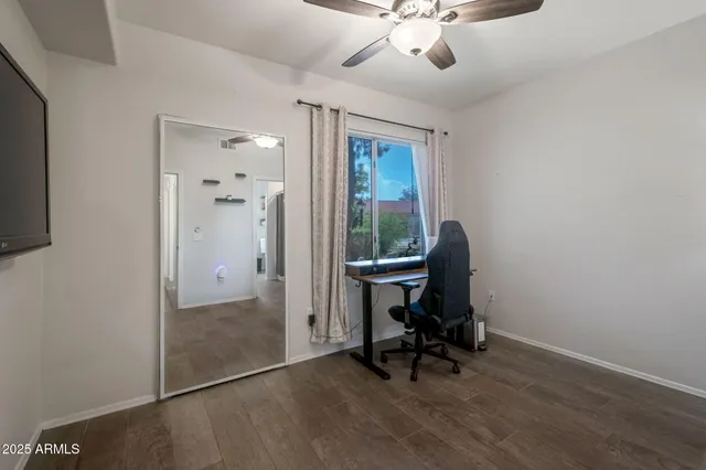 a view of a workspace with furniture and a window