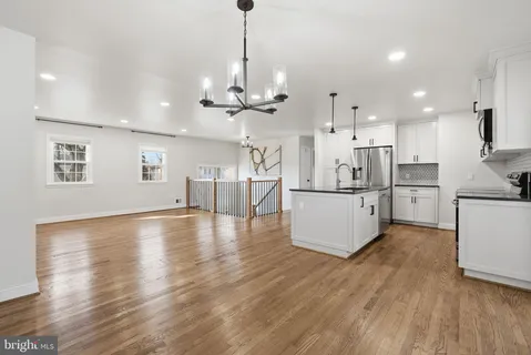 a view of a hallway with wooden floor and windows
