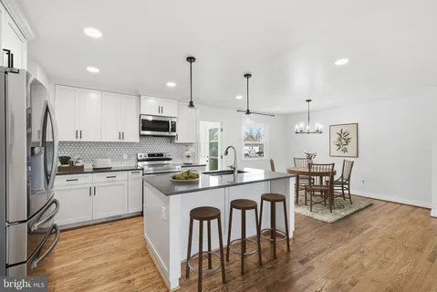 a kitchen with a sink stainless steel appliances and white cabinets