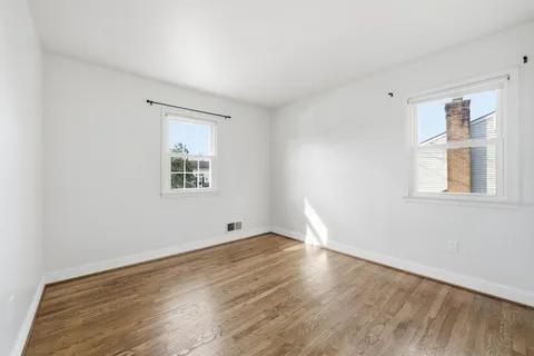 a view of an empty room with stairs and a window