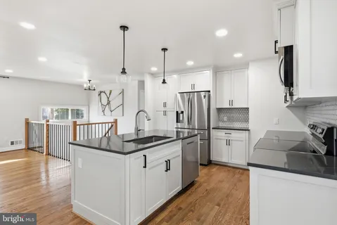 a kitchen with a stove sink and chandelier