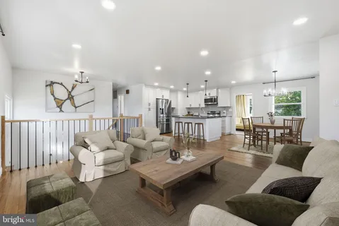 a view of kitchen with kitchen island granite countertop a stove top oven a sink and a counter top space