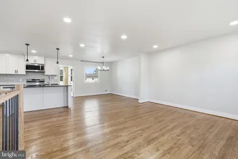 a view of a kitchen with refrigerator and wooden floor