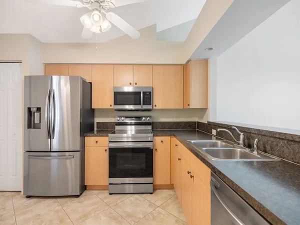 a kitchen with stainless steel appliances granite countertop a refrigerator sink and stove
