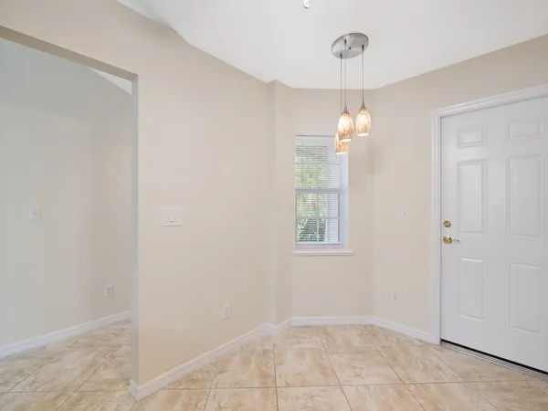 an empty room with windows and chandelier
