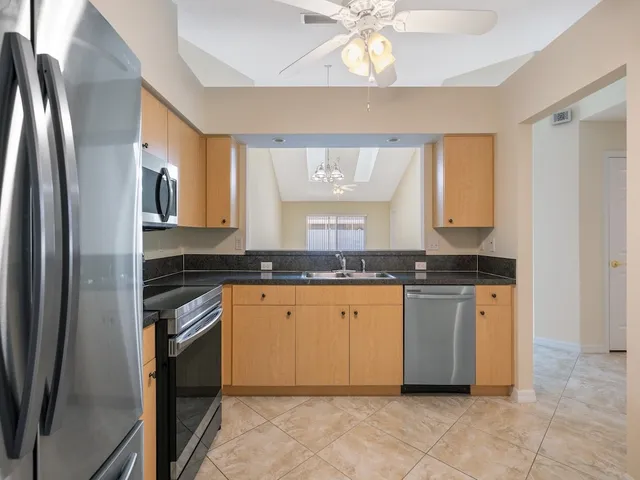 a kitchen with granite countertop a sink stainless steel appliances and cabinets