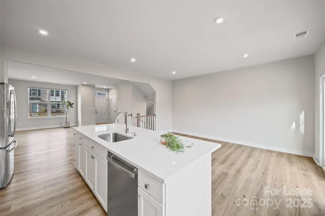 a kitchen with a sink and wooden floor