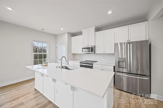 a kitchen with stainless steel appliances a refrigerator sink and microwave
