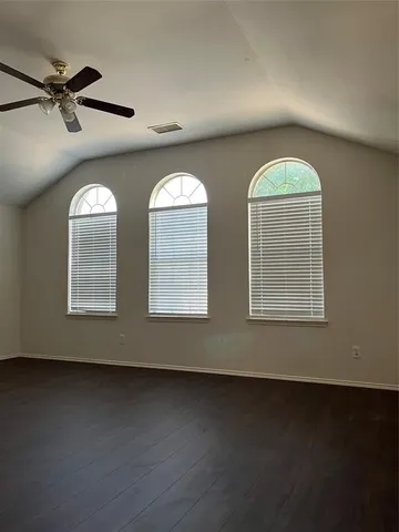 an empty room with windows and fan