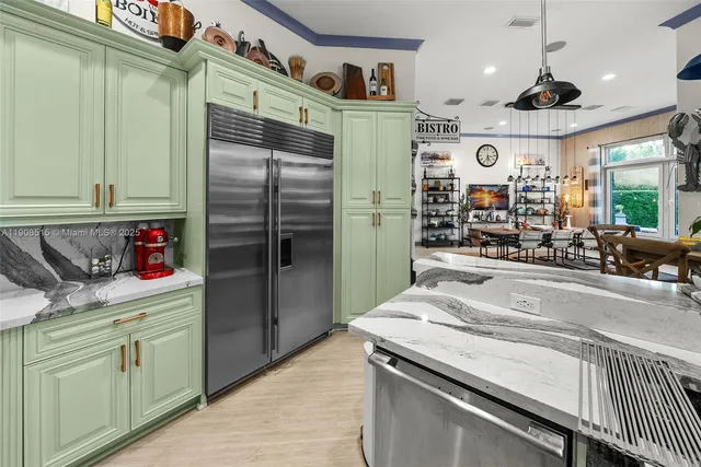 a kitchen with stainless steel appliances granite countertop a sink and a refrigerator