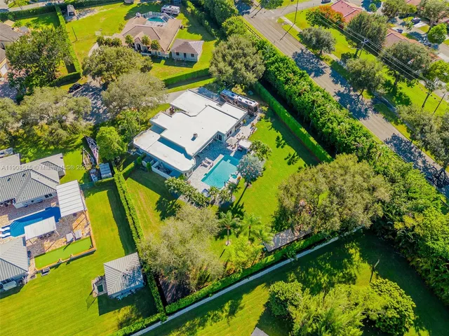 an aerial view of a residential houses with yard