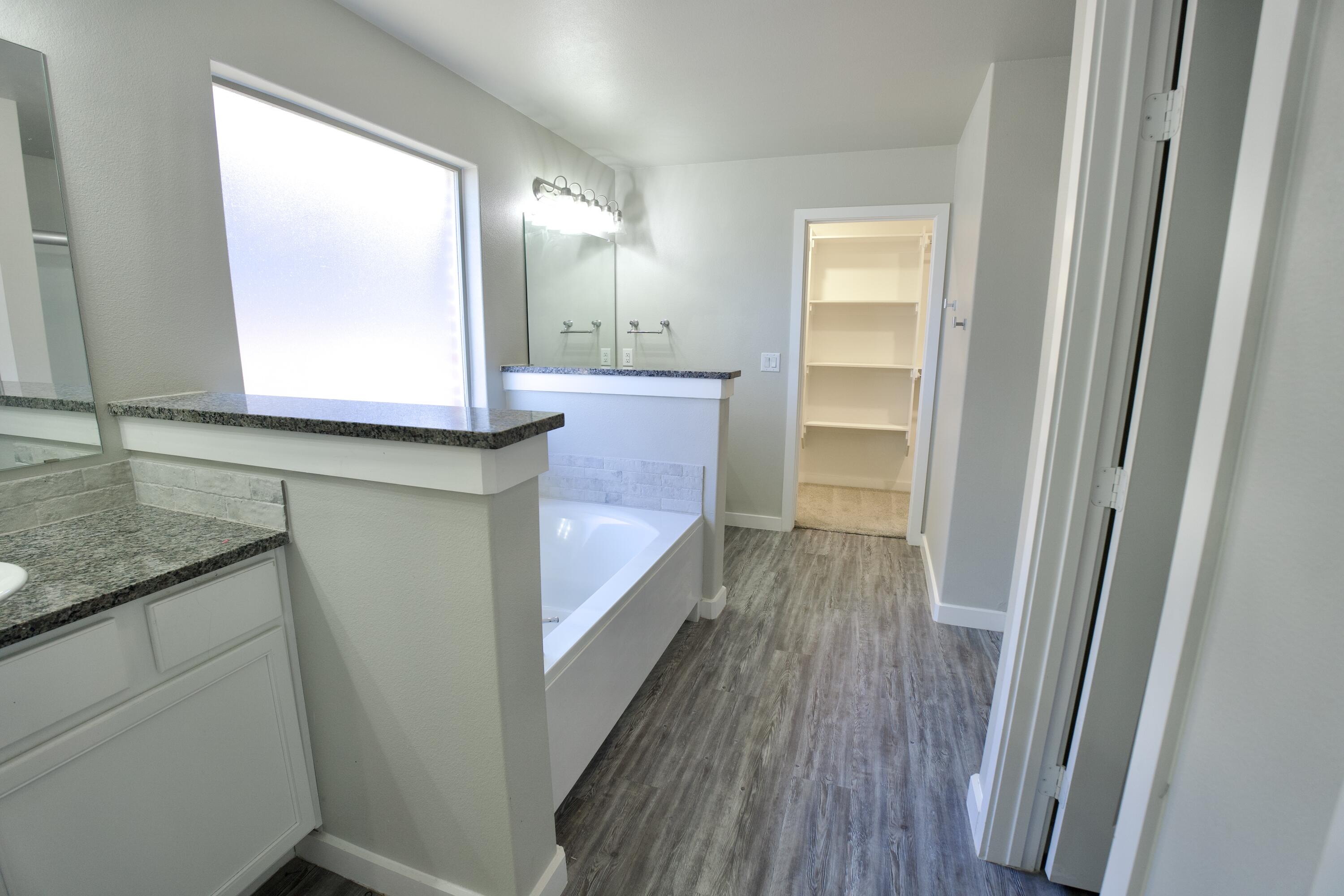 1604 137th Street Lubbock, TX 79423 - Photo 11 of 19 a bathroom with a granite countertop sink a vanity and a mirror