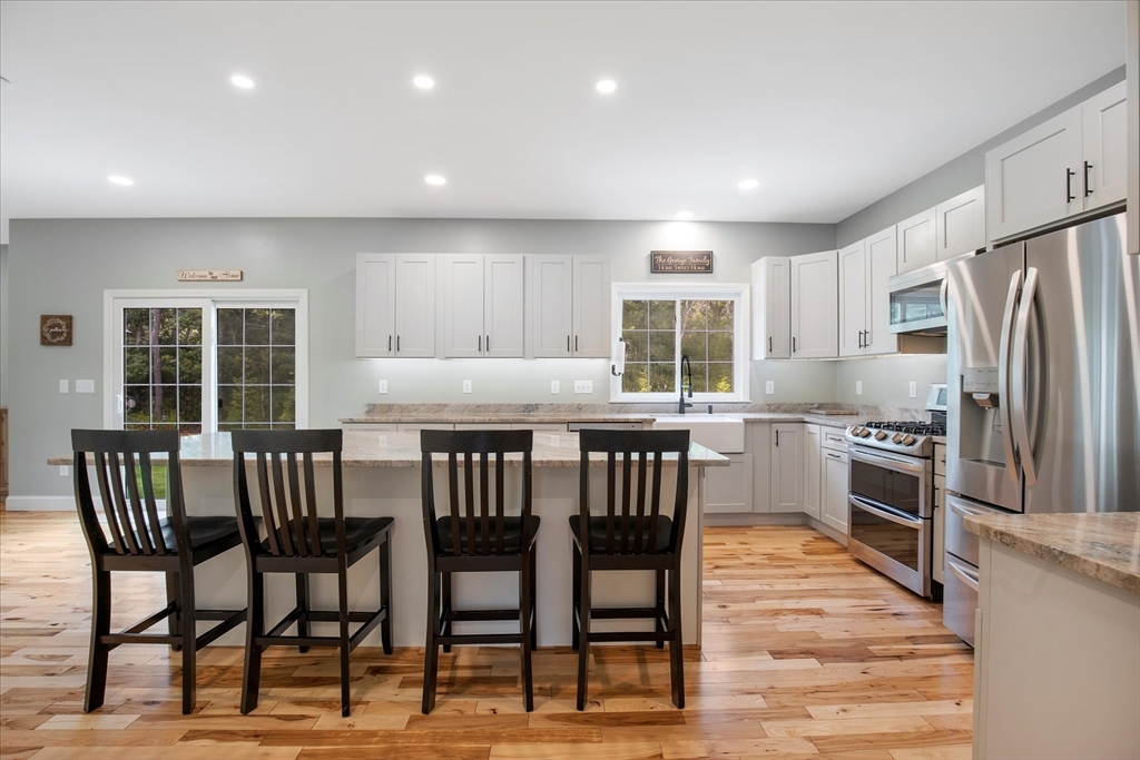 23 Pimlico Pond Road Mashpee, MA 02649 - Photo 13 of 42 a kitchen with stainless steel appliances granite countertop a stove a refrigerator a kitchen island a table and chairs