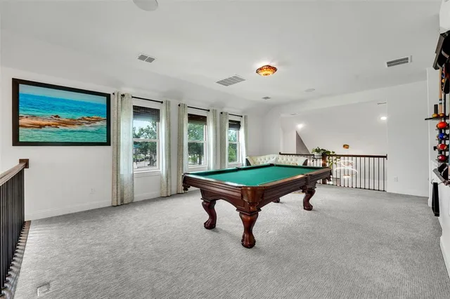 a room with pool table and windows